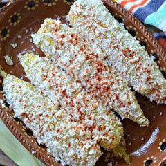 Look at the image. Wha food is it?
a) Tamales mexicanos
b) Elotes mexicanos
c) Enfrijolada
d) Fozole Blanco de Guerrero