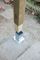 A metal piece attached to or imbedded in the footing that attaches the post to the footing and keeps the post from being exposed to moisture in the ground.
