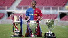 SE Samuel Eto'o standing behind 3 trophies
