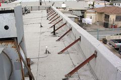 a low wall at roof's edge
portion of exterior walls of a buildg that extends above the roof