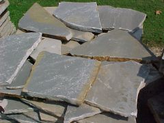 A flat stone usually not more than 4 inches thick used for outdoor paving.