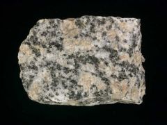 An igneous rock having crystals or grains of visible size. Consisting mainly of quartz, feldspar, and mica or other colored minerals.