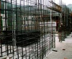 Use of steel rebars at regular intervals in a poured concrete or masonry wall. If used in a masonry wall, the rebars are bonded to the masonry with grout.