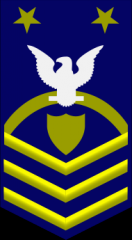 Master Chief Petty Officer of the Coast Guard Reserve Force E-9


ZERO ONE gold rocker,

ZERO THREE gold chevrons, a gold shield, a white eagle, and ZERO TWO gold stars on a field of blue.