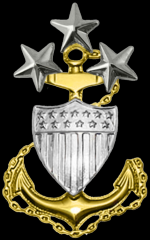 

Master Chief Petty Officer of the Coast Guard E-9
a gold anchor and silver shield with ZERO THREE silver stars on top.

 