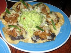 Tender pork simmered in green chiles and Anaheim peppers on crispy corn tortillas, topped with melted Jack cheese, black beans and fresh jalapeños, served with hand-hacked guacamole. 9.95