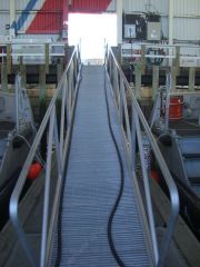 A movable ladder or ram used for boarding a vessel from a dock or pier