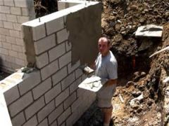 Application of mortar to the back of the facing material, or the face of the backing material.