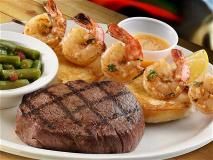 An 8 oz sirloin (cooked to the guests liking) paired with a skewer of shrimp.
*Garnish:
Garlic lemon pepper butter
Lemon wedge
Toasted fresh baked bread 
*Served on a large warm oval