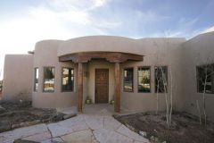 Thick, earth-colored adobe walls and flat roofs with rounded parapets