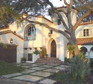 Red-tiled roofs, stucco siding, arched entryways and windows, and decorative tiles by the windows and doors