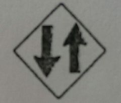 This yellow sign means:

A.  One-way road widens into two lanes ahead.
B.  Vehicles on this road travel in two directions.
C.  There is a divided highway ahead.