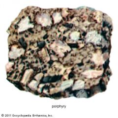 consisting of large-grained crystals, such as feldspar or quartz, dispersed in a fine-grained feldspathic matrix or groundmass