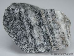 foliated rock that has a banded appearance and is made up of granular mineral grains. It typically contains abundant quartz or feldspar minerals.