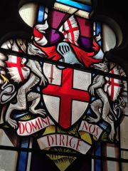 Describe the Coat of Arms in the right window.