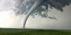    tornado 
a localized, violently destructive windstorm occurring over land, especially in the Middle West, and characterized by a long,
