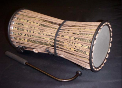 Ghana. 2 drum heads held under the arm with strings attached to change pitch. Membranophone.
