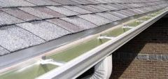 A trough fixed under or along the eaves for draining rainwater from a roof.