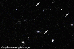 Why are the three very distant galaxies pointed out in this image (see white arrows) red in color?