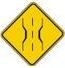 This sign means?
A) Soft shoulder warning.
B) Left lane ends ahead.
C) Narrow bridge warning.
D) Merging traffic from the right.