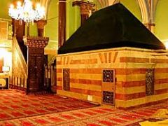 (n) "empty tomb" erected in honor of a person whose remains are elsewhere;
in Islamic grave architecture, it refers to the upper visible chamber located well above the real grave